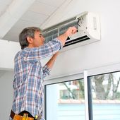 Hombre realizando reparación de aire acondicionado